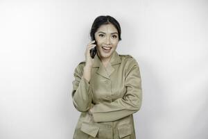 glimlachen regering arbeider vrouw terwijl pratend Aan de telefoon. pns vervelend khaki uniform. foto