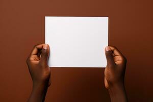 een menselijk hand- Holding een blanco vel van wit papier of kaart geïsoleerd Aan bruin achtergrond. ai gegenereerd foto