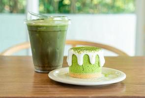 Matcha groene thee cheesecake met groene thee beker op tafel in café restaurant foto