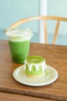 Matcha groene thee cheesecake met groene thee beker op tafel in café restaurant foto