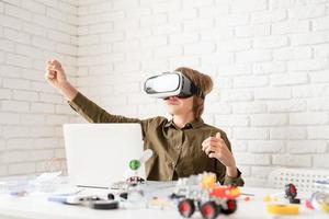 lachende tienerjongen in virtual reality-bril die het spel speelt foto