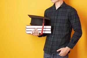 universiteitsman is blij met afstuderen op gele achtergrond foto