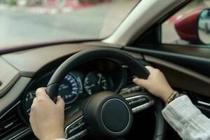 vrouw het rijden auto. meisje gevoel gelukkig naar rit Holding stuurinrichting wiel en op zoek Aan weg foto