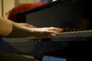 detailopname Aan de handen van een vrouw spelen de piano met muziek- sleutels foto