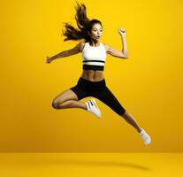 een tiener- meisje jumping in sport- kleding Aan geel achtergrond foto