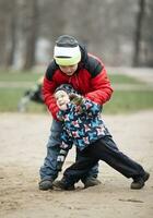 twee jong broers spelen buitenshuis in winter foto