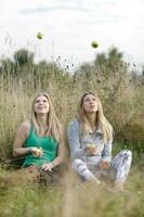 twee speels meisjes jongleren buitenshuis foto