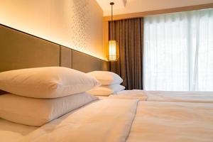 witte kussendecoratie op bed in de slaapkamer van het hotelresort