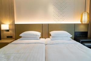 witte kussendecoratie op bed in de slaapkamer van het hotelresort