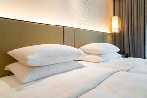 witte kussendecoratie op bed in de slaapkamer van het hotelresort foto