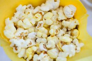 smakelijk popcorn in geel papier zak foto