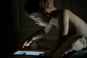 weinig jongen gebruik makend van tablet pc Bij nacht foto