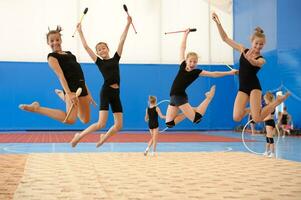 meisjes met Indisch Clubs gedurende hoog springen foto