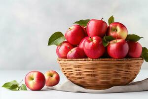 een mand gevulde met vers geplukt appels symboliseert de overvloedig oogst van herfst tegen een minimaal wit backdrop foto
