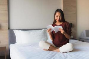 portret mooie jonge aziatische vrouwen die boek op bed lezen reading foto