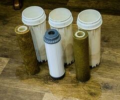 drie gebruikt water filters met sporen van aarde, klei en verontreinigingen. vervangen meertraps water filter inktpatronen. foto