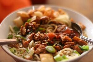 selectief focus mie ajam, mie ayam is een gemeenschappelijk Indonesisch schotel van gekruid geel tarwe noedels bekroond met in blokjes gesneden foto