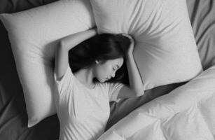 jong mooi meisje slapen alleen in groot comfortabel bed Bij nacht, top visie. foto