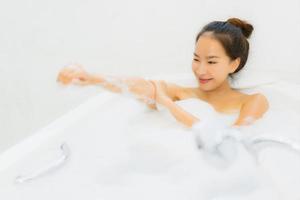 portret mooie jonge aziatische vrouw neemt een badkuip in de badkamer