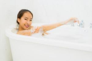 portret mooie jonge aziatische vrouw neemt een badkuip in de badkamer