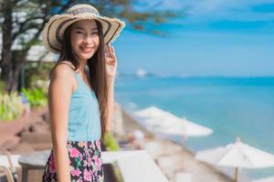 portret mooie jonge aziatische vrouw gelukkige glimlach ontspannen rond strand oceaan en zee and foto