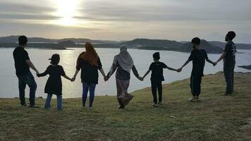 silhouet van een groep van mensen Holding handen Bij zonsondergang, slechts heuvel, lombok, Indonesië foto