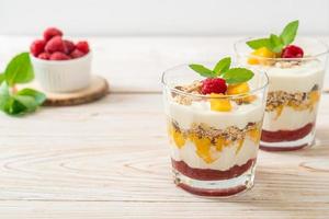 zelfgemaakte verse mango en verse framboos met yoghurt en granola - healthy food style foto