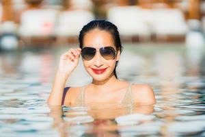 portret jonge mooie aziatische vrouw gelukkige glimlach en ontspan in het zwembad rond het hotelresort foto