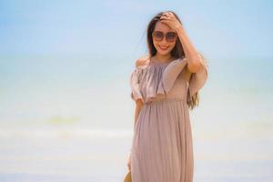 portret mooie jonge aziatische vrouw gelukkige glimlach ontspannen op het tropische strand zee oceaan foto