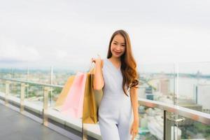 portret mooie jonge aziatische vrouw blij en glimlach met boodschappentas van warenhuis foto