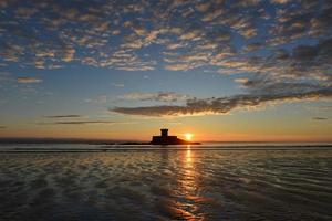 st ouens strand jersey uk 19e eeuwse rocco toren met lente zonsondergang foto