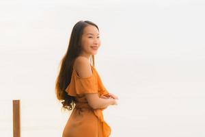 portret mooie jonge aziatische vrouw levensstijl gelukkige glimlach met vrije tijd bijna zee strand oceaan foto