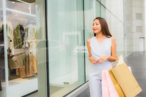 portret mooie jonge aziatische vrouw blij en glimlach met boodschappentas van warenhuis foto
