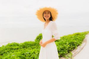 portret mooie aziatische vrouw draagt hoed met glimlach gelukkige vrije tijd op het strand en de zee in vakantievakantie foto