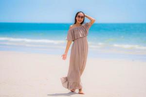 portret mooie jonge aziatische vrouw gelukkige glimlach ontspannen op het tropische strand zee oceaan foto