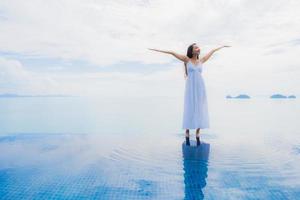 portret jonge aziatische vrouw ontspannen glimlach gelukkig rond het zwembad in hotel en resort foto