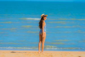 portret mooie jonge aziatische vrouw gelukkige glimlach ontspannen op het tropische strand zee oceaan voor vrije tijd reizen foto