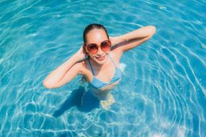 portret mooie jonge aziatische vrouw glimlach gelukkig ontspannen en vrije tijd in het zwembad foto