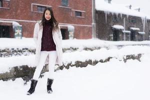 mooie jonge aziatische vrouw glimlach en blij met reisreis in otaru canal hokkaido japan foto