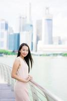 mooie aziatische vrouw glimlach en blij om te reizen in singapore city foto
