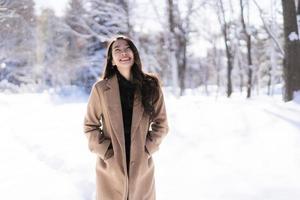 portret jonge mooie aziatische vrouw glimlach gelukkig reizen en genieten met sneeuw winterseizoen foto