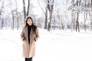 portret jonge mooie aziatische vrouw glimlach gelukkig reizen en genieten met sneeuw winterseizoen foto