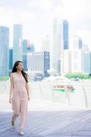 mooie aziatische vrouw glimlach en blij om te reizen in singapore city foto