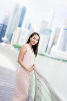 mooie aziatische vrouw glimlach en blij om te reizen in singapore city foto