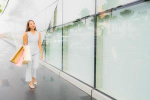 portret mooie jonge aziatische vrouw blij en glimlach met boodschappentas van warenhuis foto