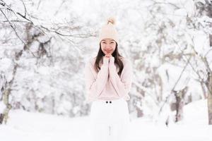 portret jonge mooie aziatische vrouw glimlach gelukkig reizen en genieten met sneeuw winterseizoen foto