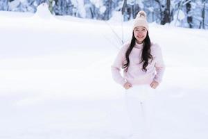 portret jonge mooie aziatische vrouw glimlach gelukkig reizen en genieten met sneeuw winterseizoen foto