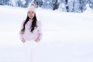 portret jonge mooie aziatische vrouw glimlach gelukkig reizen en genieten met sneeuw winterseizoen foto