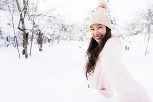 portret jonge mooie aziatische vrouw glimlach gelukkig reizen en genieten met sneeuw winterseizoen foto