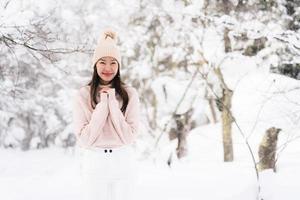 portret jonge mooie aziatische vrouw glimlach gelukkig reizen en genieten met sneeuw winterseizoen foto